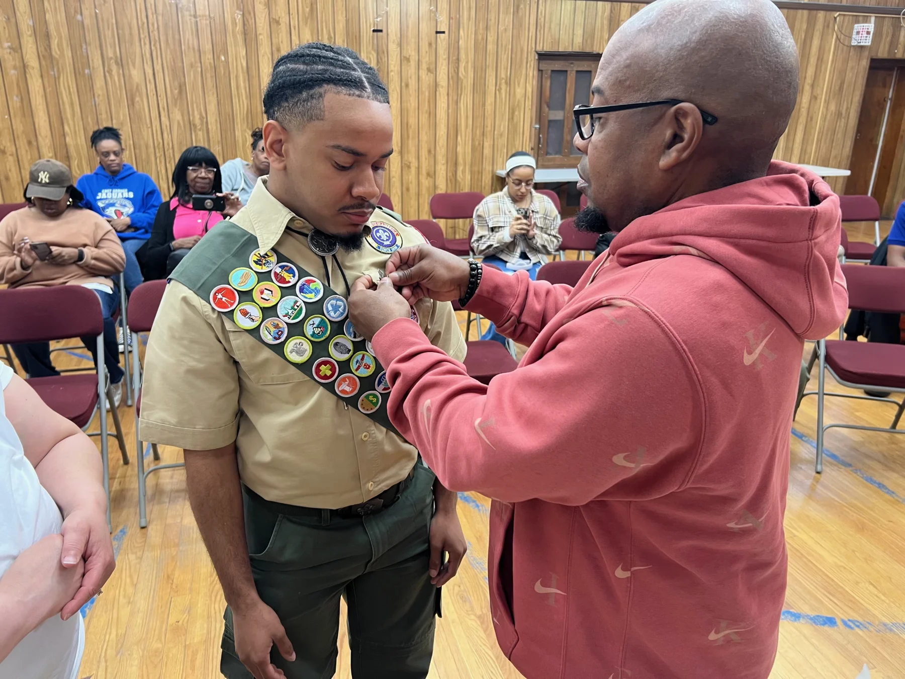 A family member helps with the Scout pinning.
