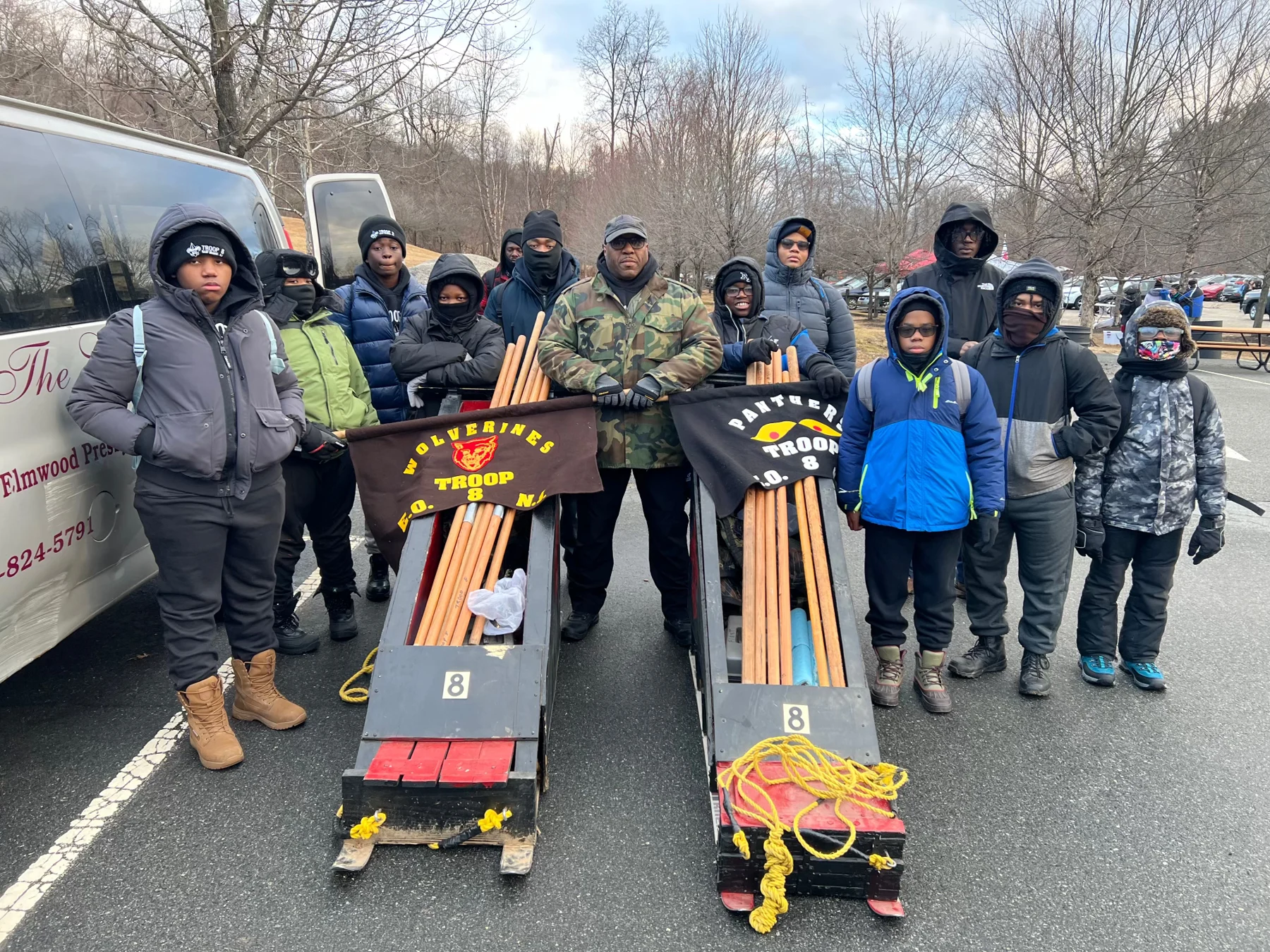 Scouts and adults posing with decorated Derby sleds