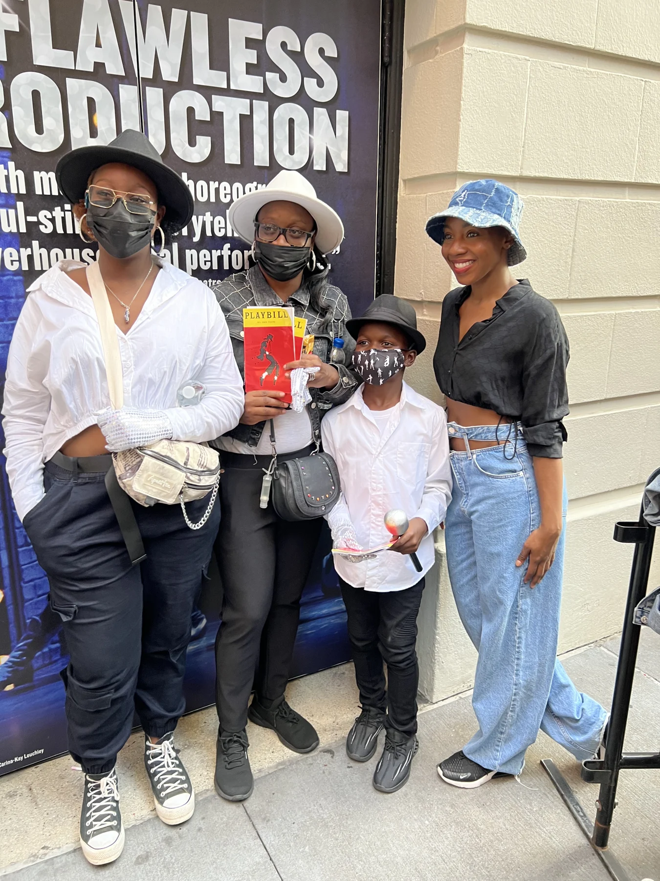Members of the outing pose together outside the theatre with a show program.