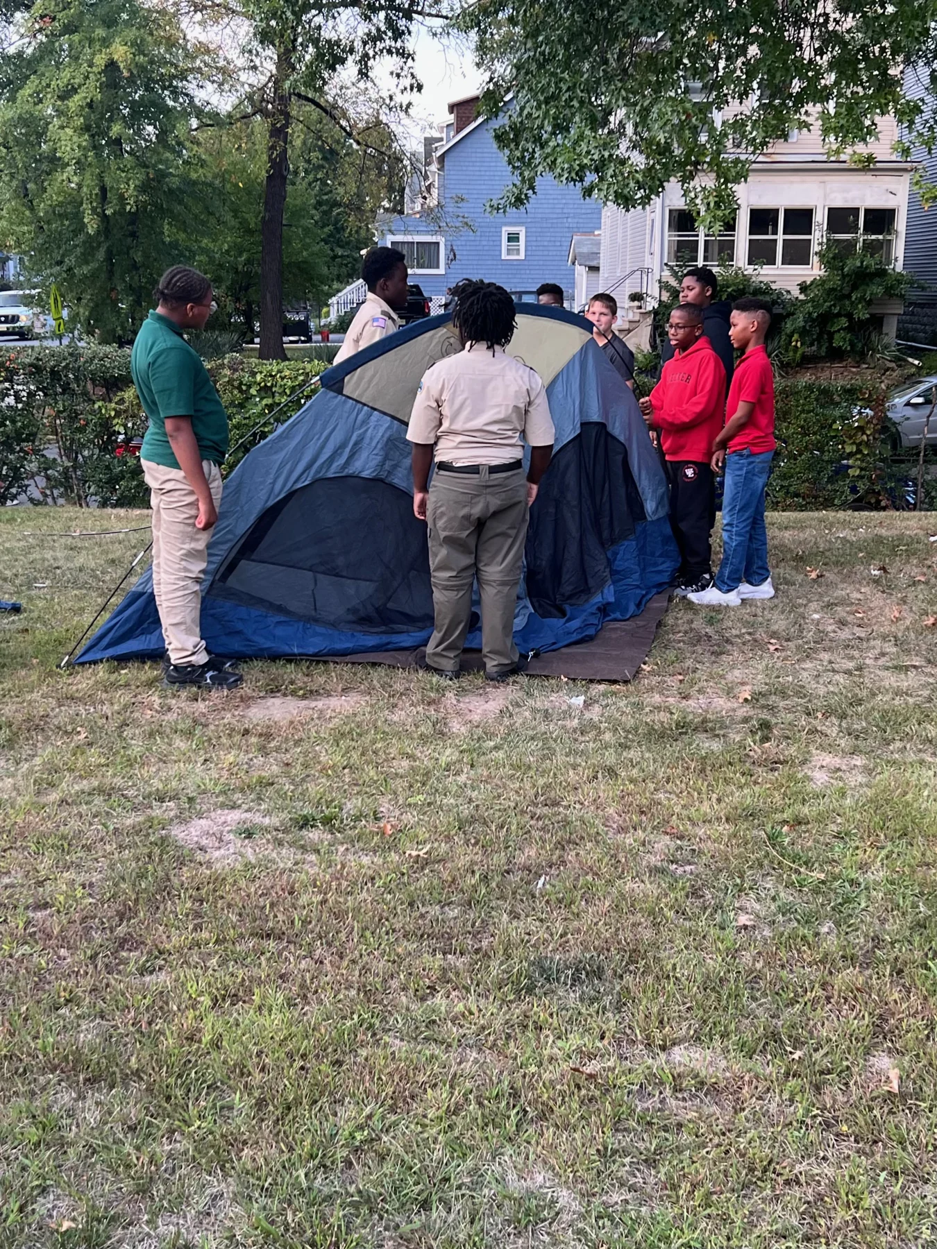 Scouts work together to set up a tent.